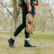 Low back ultralight folding camping chair in compact carry pouch on grassy outdoor setting.